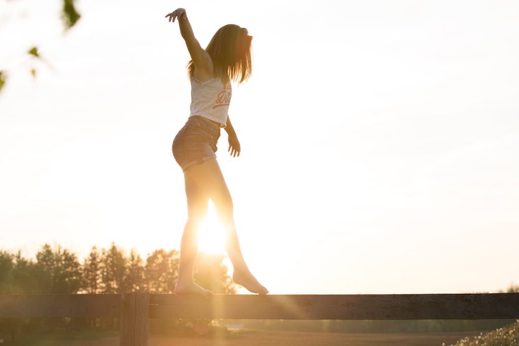 A teenage girl balancing as the sun sets