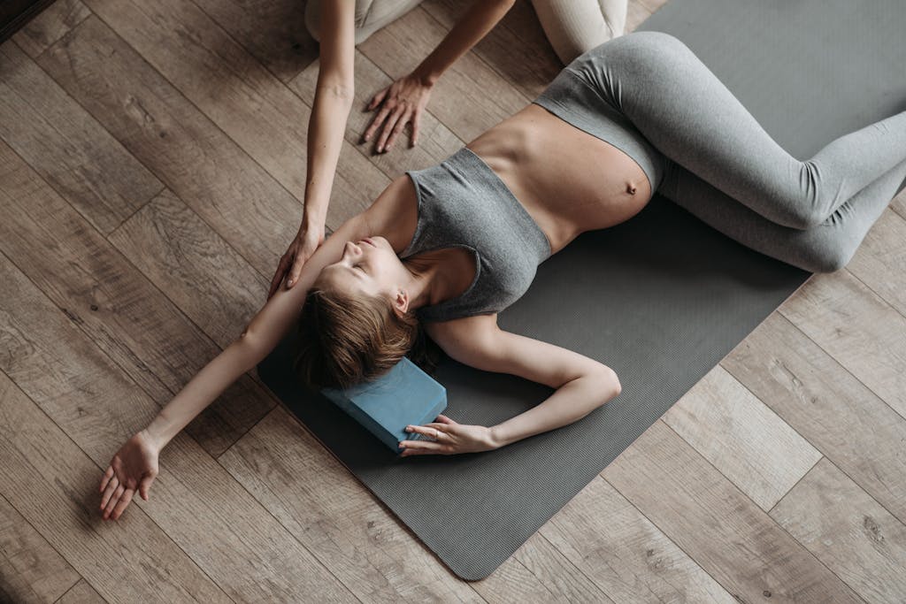 A pregnant woman doing a spinal twist in yoga
