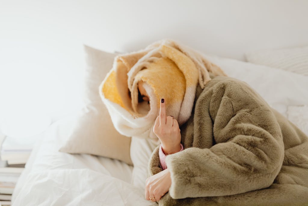 A woman with a towel on her head and her middle finger up