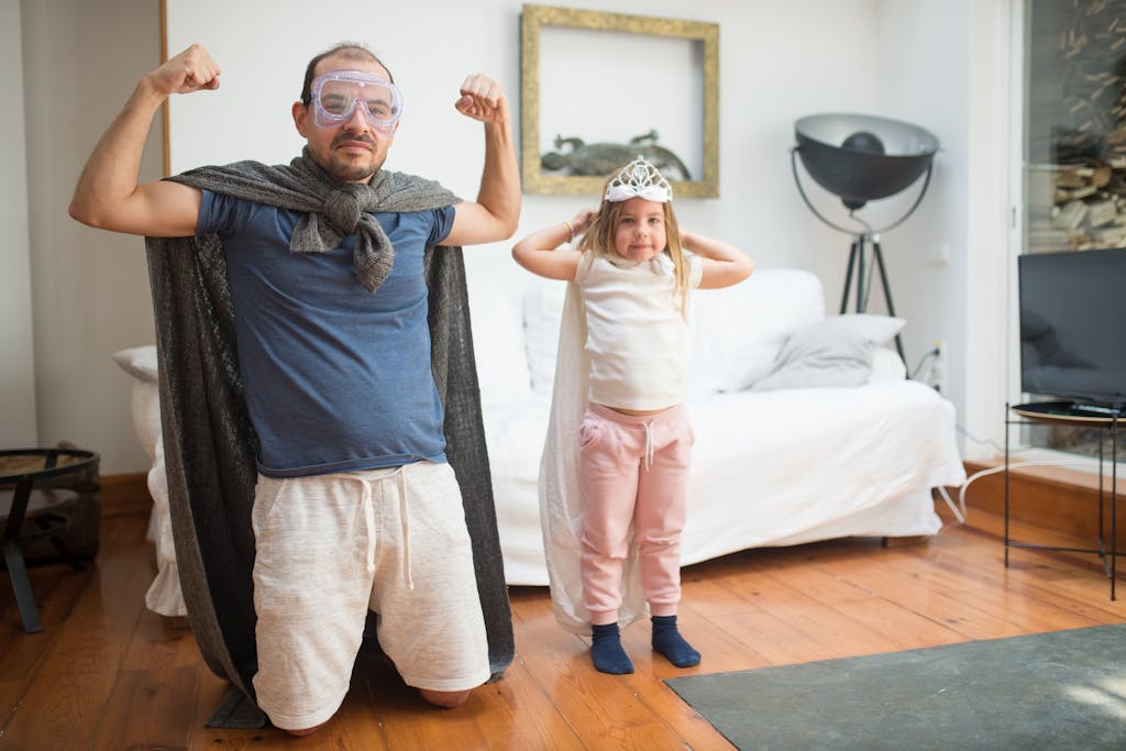 A father and his daughter flexing their muscles in yoga 